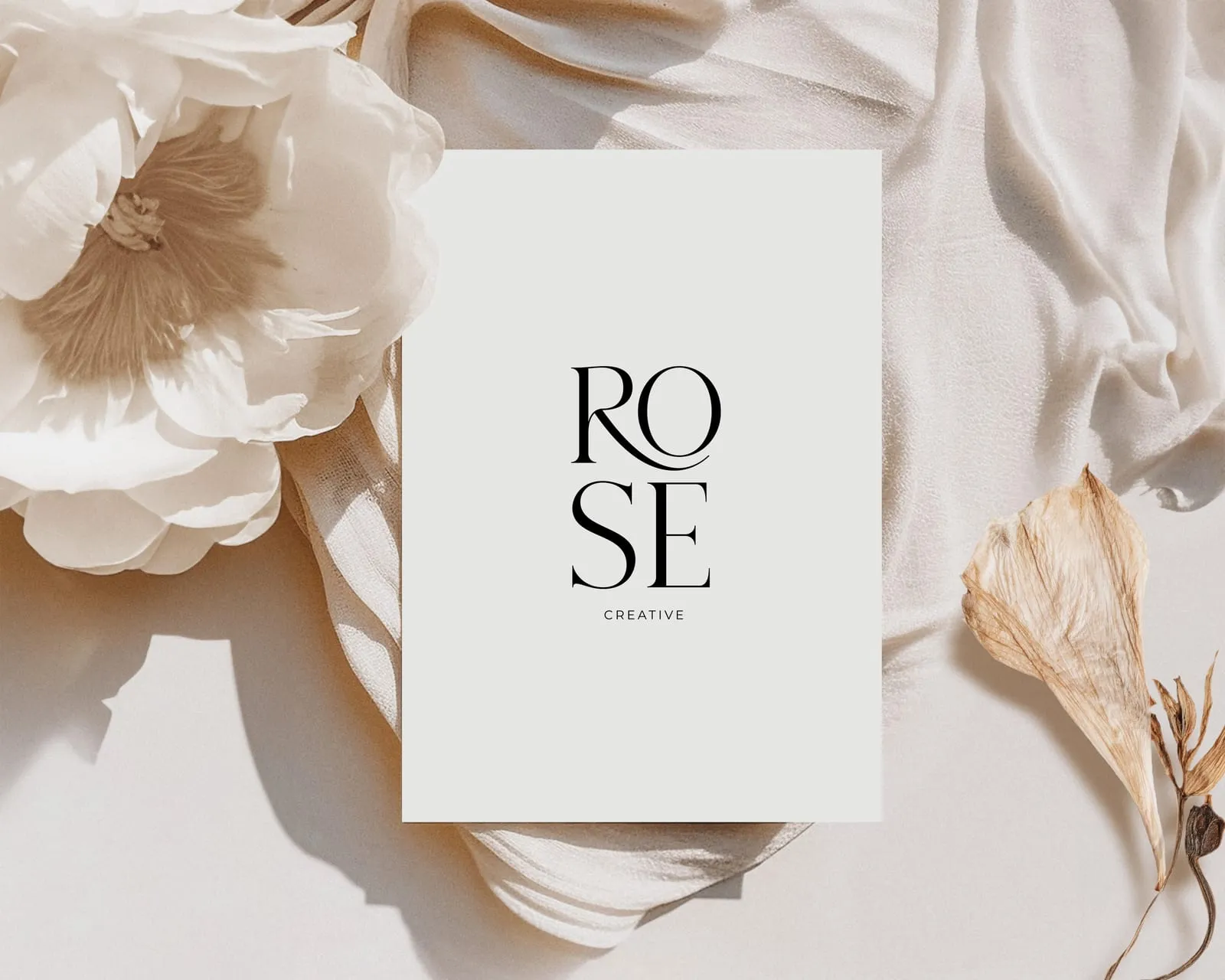 Identité Rose Creative Atelier : le logo « ROSE CREATIVE » posé parmi des pivoines blanches et un voile de soie.